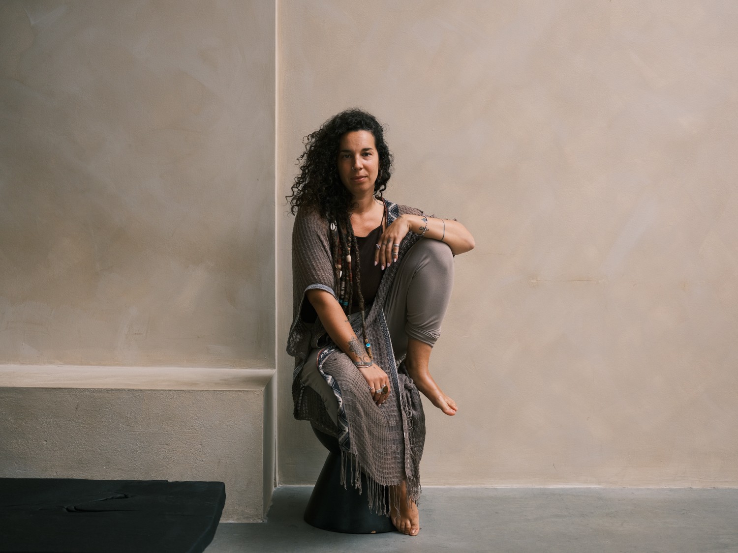 A wellness practitioner sitting barefoot in an earthy minimalist studio during her holistic brand photography in Amsterdam session