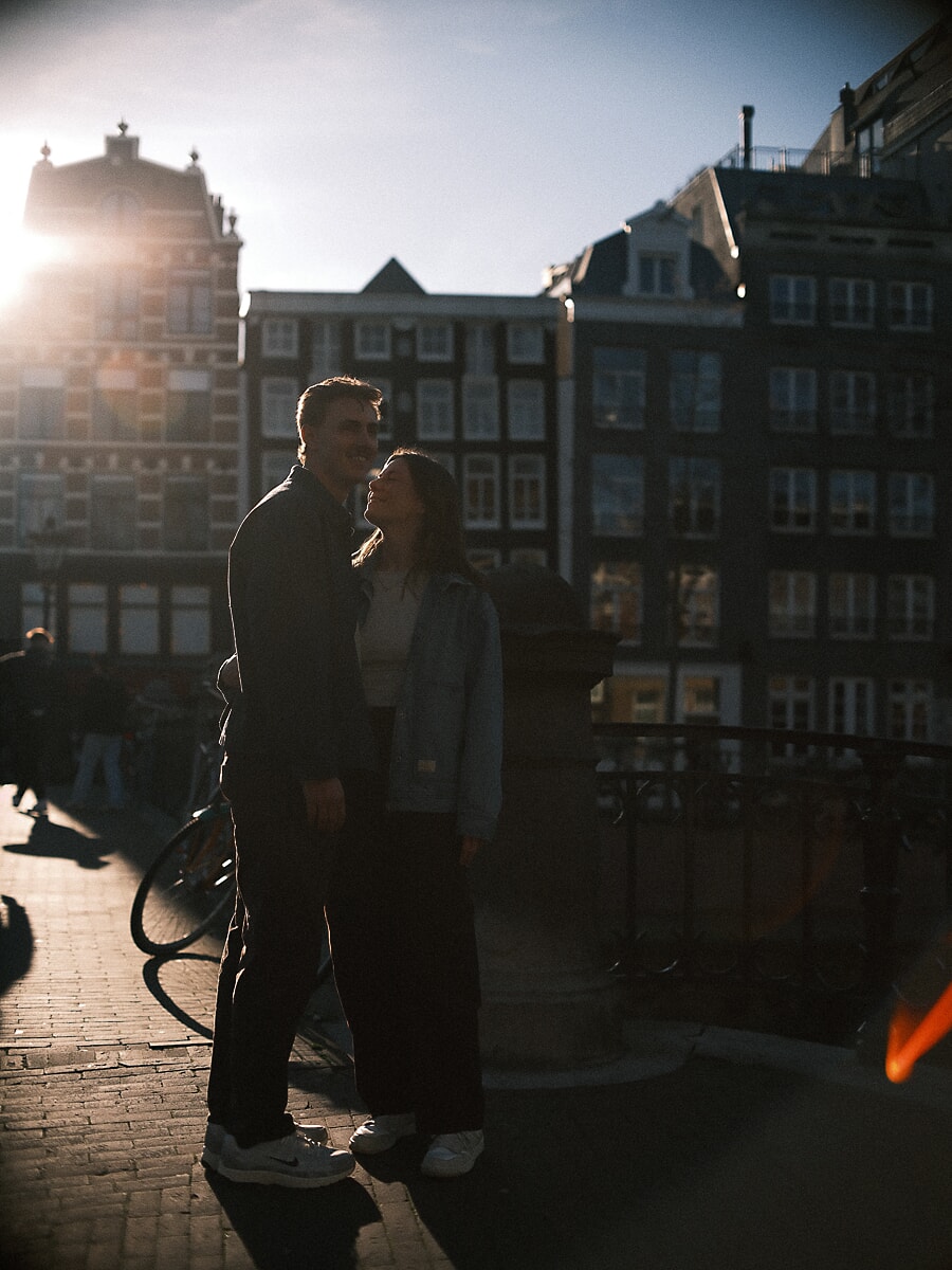 Engagement SP13 Cinematic backlit engagement portrait of a couple kissing on an Amsterdam bridge at golden hour