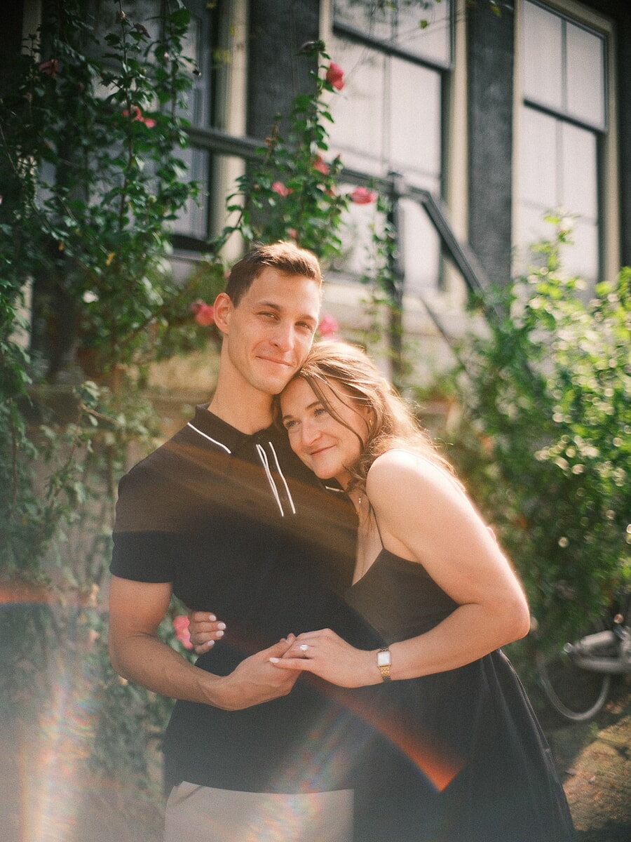 Engagement SP8 Romantic engagement portrait of partners embracing in front of a rose-covered Amsterdam façade