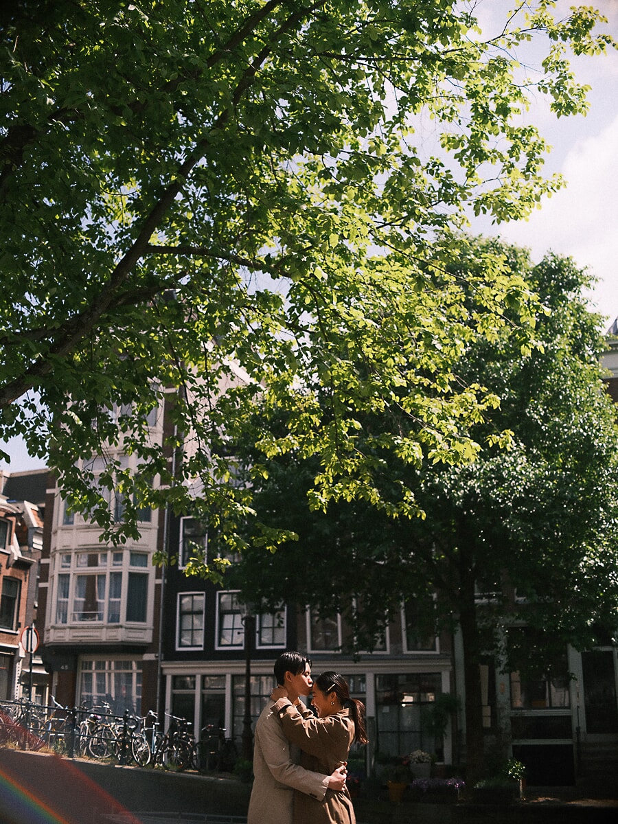 Loveshoot SP3 Romantic couple kissing under a leafy tree beside an Amsterdam canal lined with bicycles