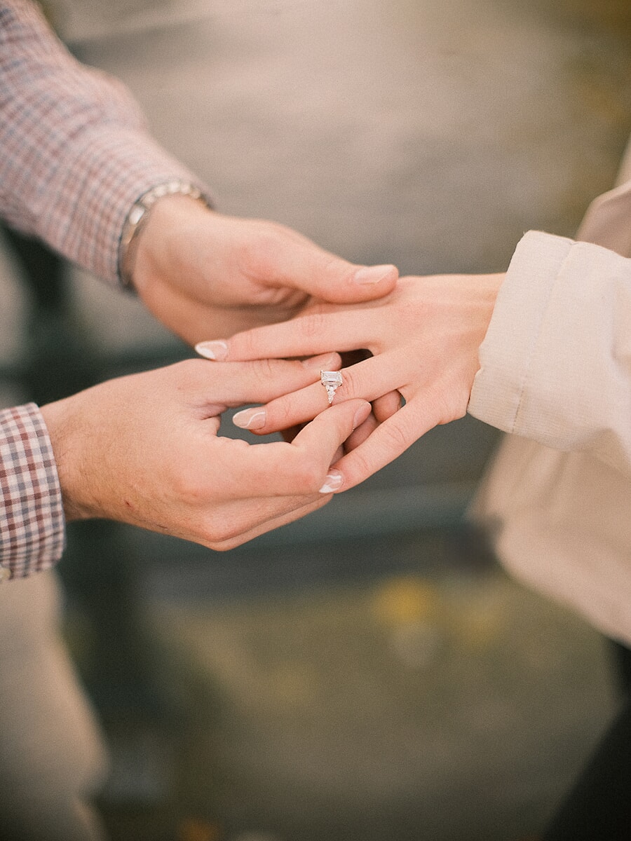 Proposal SP11 Cinematic close-up of a man placing the ring on his fiancée's hand during a surprise proposal shoot