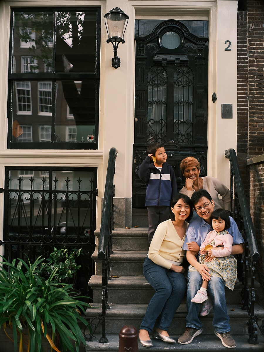 Family SP1 Seated on the steps of a canal house, three generations gather as a grandmother smiles beside her grandchildren, captured by a family photographer in Amsterdam