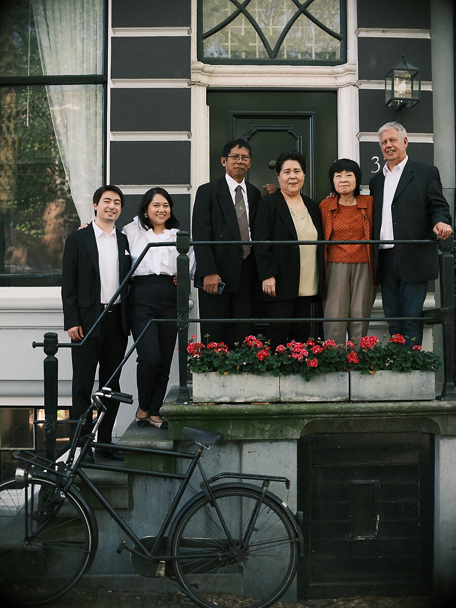 Group Family SP1 Formally dressed family of six by a canal house doorway for a golden jubilee portrait, a bicycle resting against the steps in Amsterdam