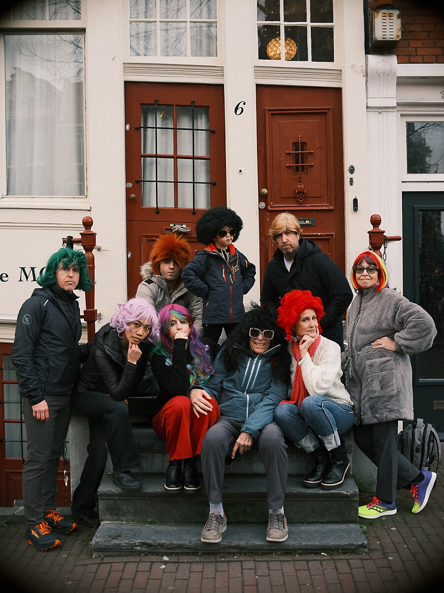 Group Family SP9 Playful family portraits of relatives in brightly coloured wigs and sunglasses seated on an Amsterdam stoop