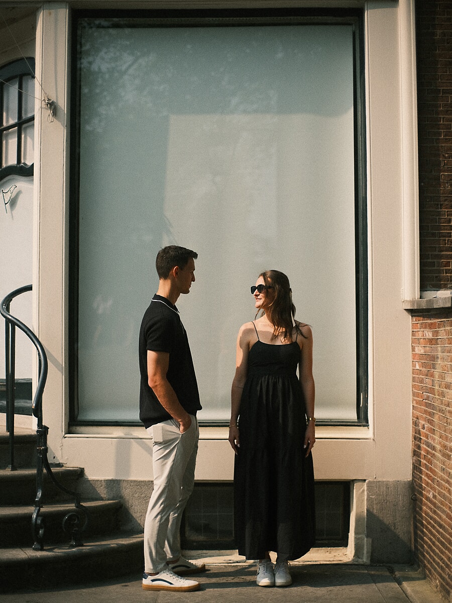 Engagement SP4 Elegant engagement portrait of a couple in black outfits beside a tall window of an Amsterdam canal house
