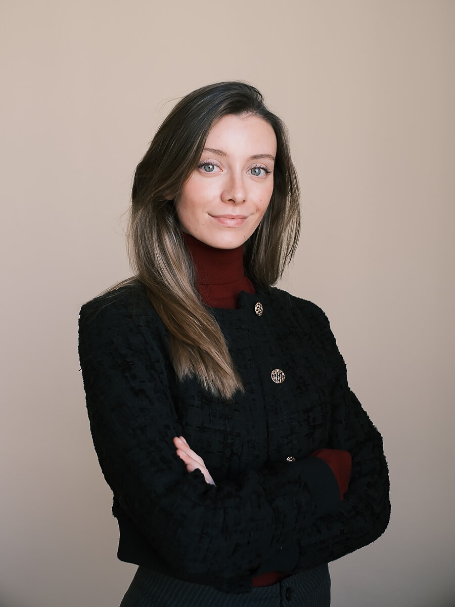 Woman in a black tweed jacket over a burgundy rollneck with her arms folded, a business portrait in Amsterdam