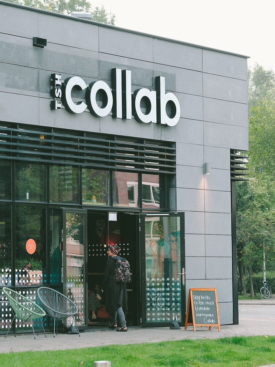 Exterior of a grey-clad coworking building, signage above the glass frontage, property photography for an Amsterdam business