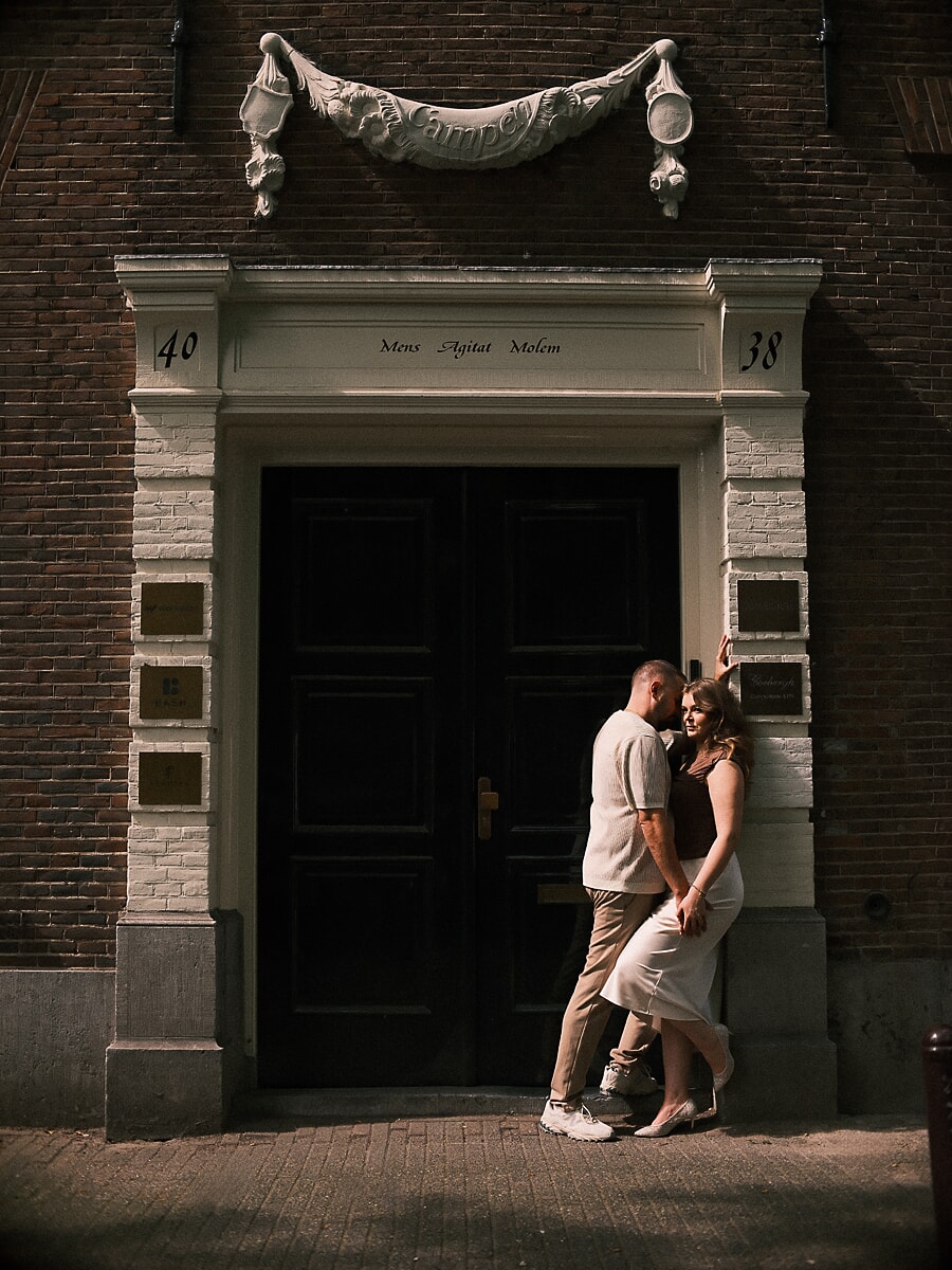 Couple leaning into each other in a grand Amsterdam canal-house doorway