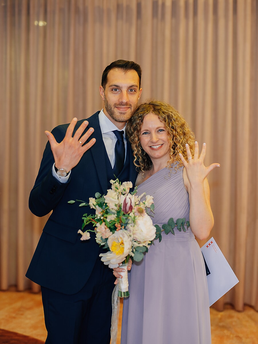 Wedding Ceremony SP33 Just-married couple showing their wedding rings to the camera, the bride in lilac holding her bouquet and marriage certificate at the municipality, a happy wedding photo