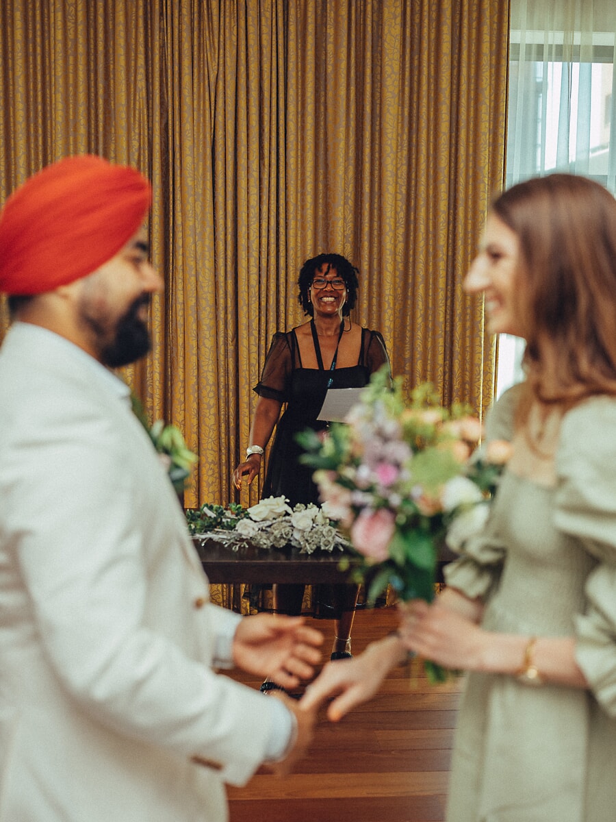 Wedding Ceremony SP9 Groom in a cream suit and red turban exchanging rings with his bride before the celebrant, captured in candid civil wedding ceremony photos