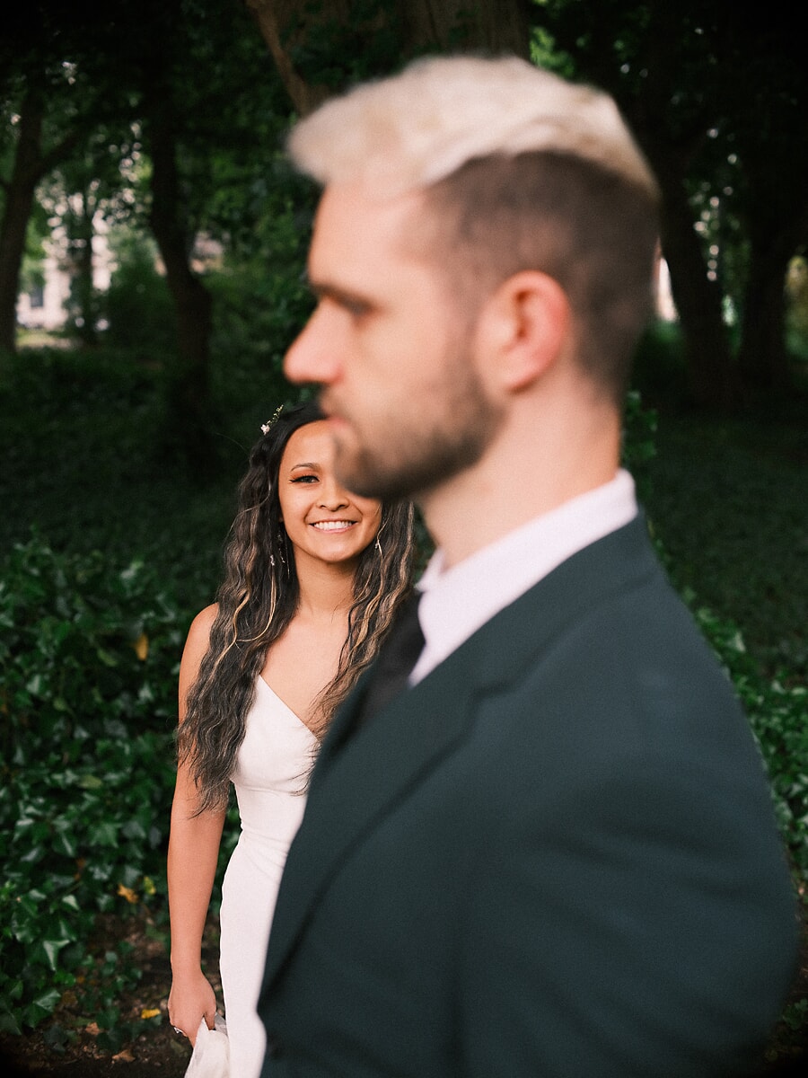 Wedding Bridal SP14 Smiling over her groom's shoulder against a wall of ivy, the bride poses for a wedding photographer in Amsterdam