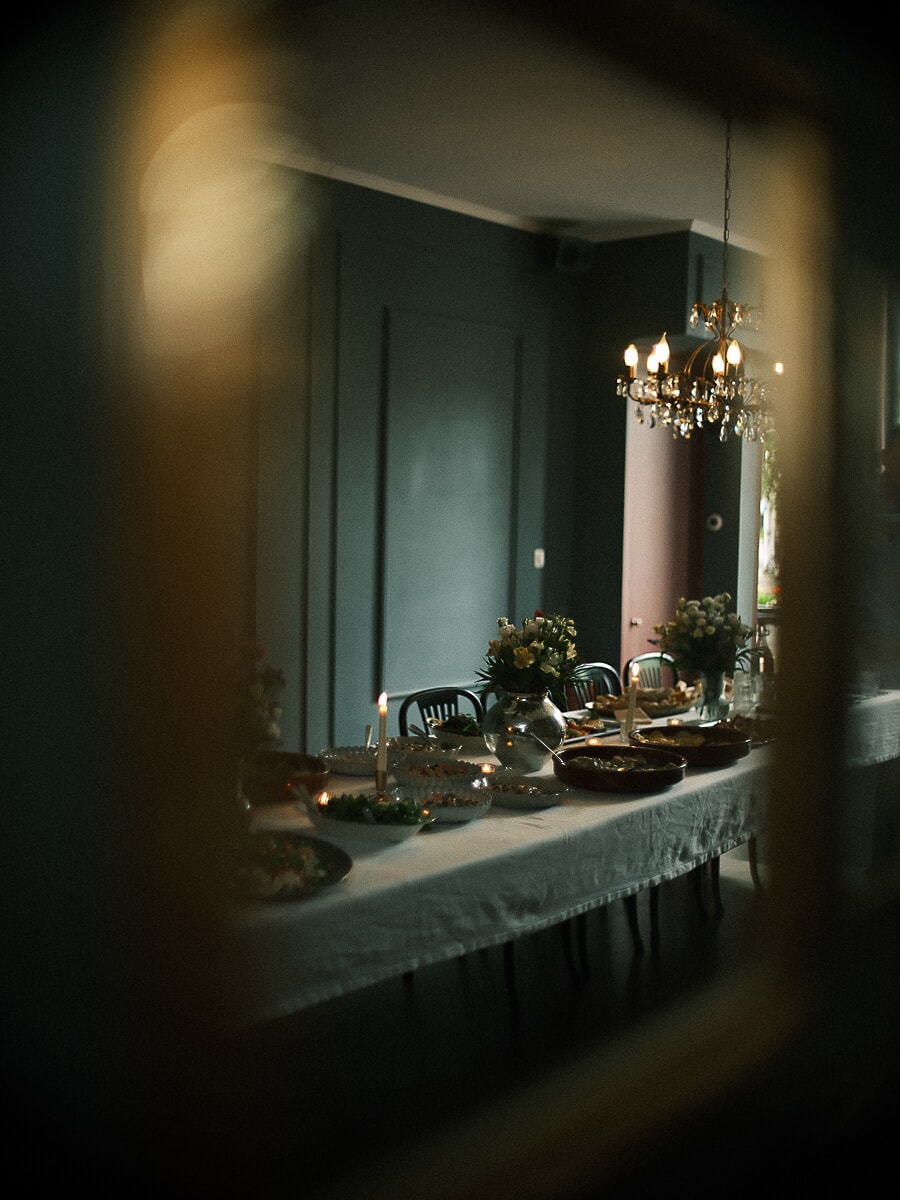 Wedding SP13 Long candlelit dinner table with flowers and silverware mirrored in an antique frame, a moody detail from the wedding photography